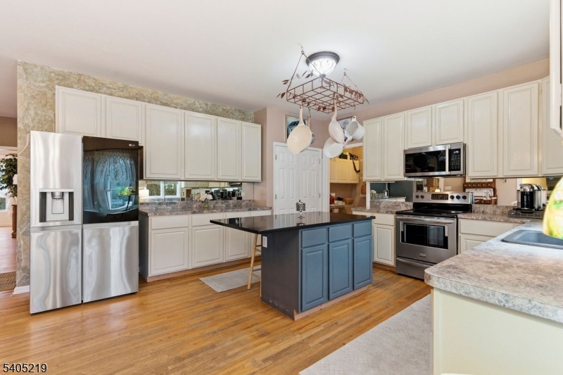 15 Mountainview Drive Andover, NJ 07821 - Photo 13 of 48 a kitchen with stainless steel appliances granite countertop a refrigerator a stove top oven a sink dishwasher and white cabinets with wooden floor