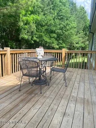 a view of deck with chairs a barbeque with wooden floor and fence