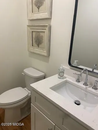 a bathroom with a toilet sink and mirror