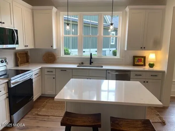 a kitchen with a table chairs sink and cabinets