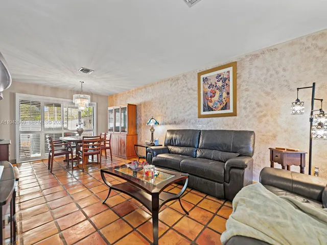 a living room with furniture a dining table and chairs with wooden floor