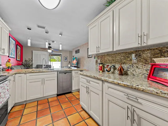 a kitchen with granite countertop white cabinets and white appliances