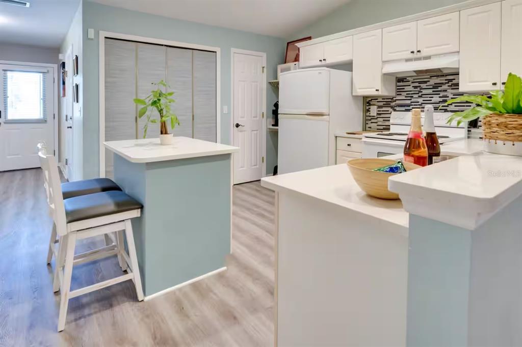 6355 Northwest 106th Place Alachua, FL 32615 - Photo 5 of 11 a kitchen with kitchen island a sink a refrigerator and a counter top space
