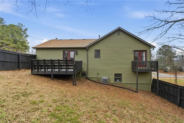 a view of a house with a yard and wooden fence