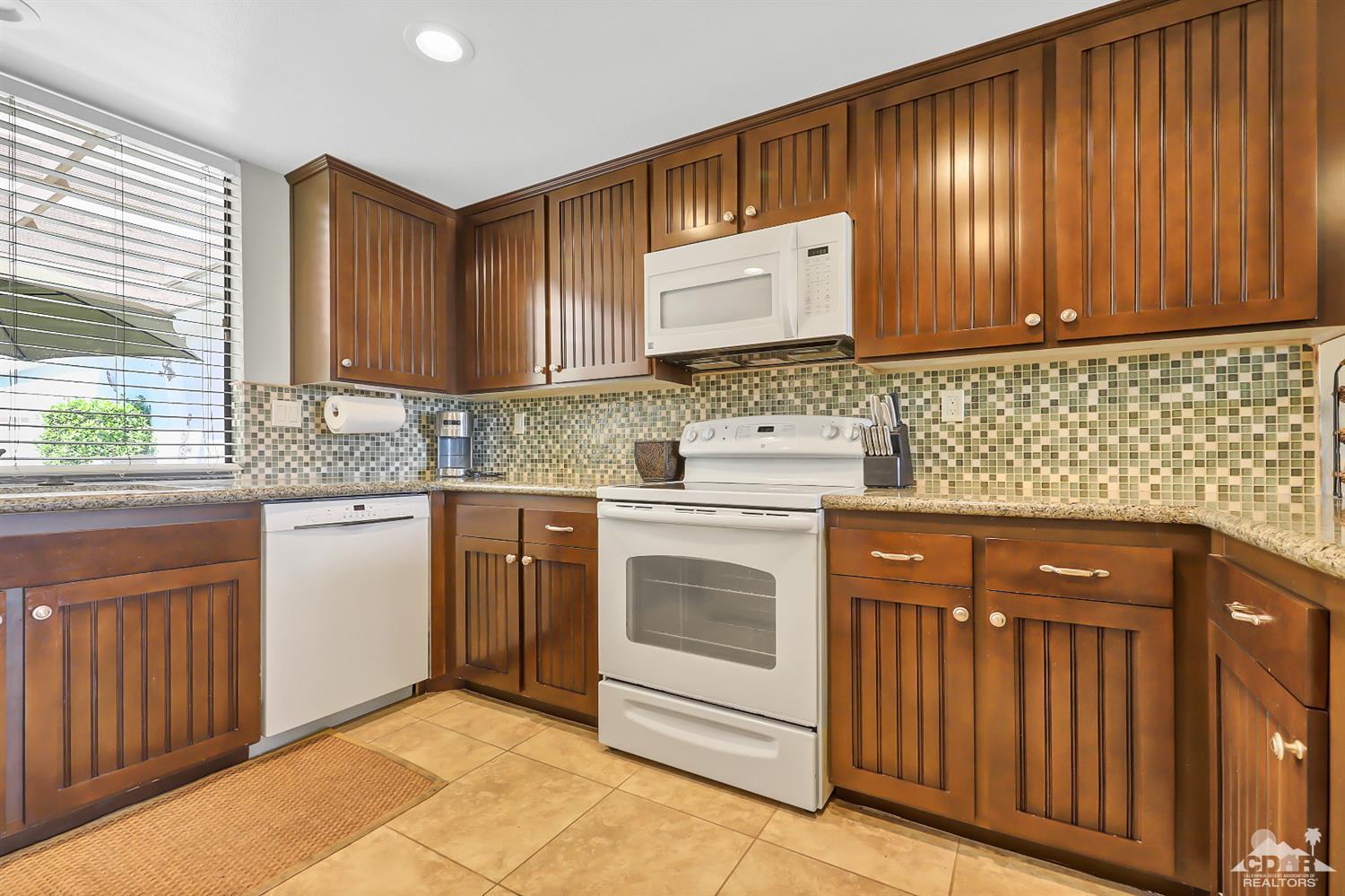 52 Durango Circle Rancho Mirage, CA 92270 - Photo 6 of 20 a kitchen with stainless steel appliances granite countertop wooden cabinets a stove and a sink