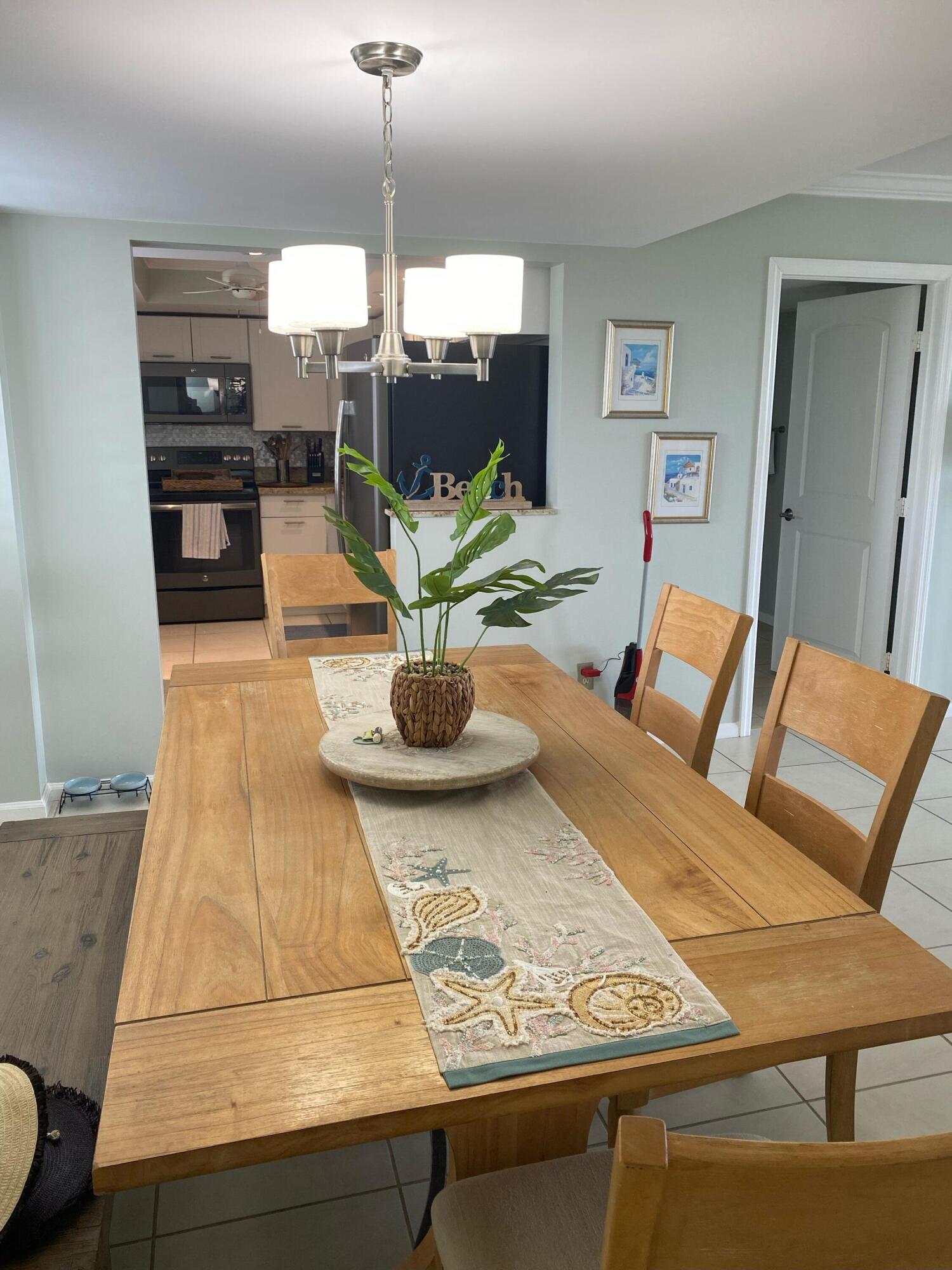1605 Highway 1, Unit 401M3 Jupiter, FL 33477 - Photo 3 of 28 a living room with dining table and chairs