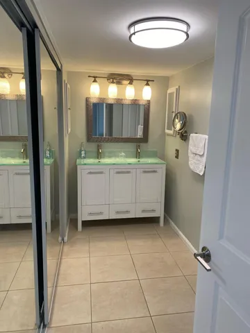 a bathroom with a double vanity sink a mirror and a bathtub