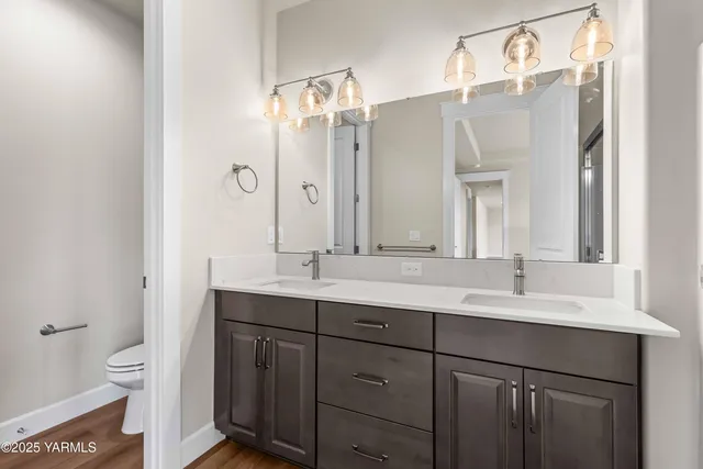 a bathroom with a double vanity sink mirror and toilet