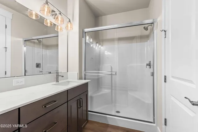 a bathroom with a shower sink vanity and mirror