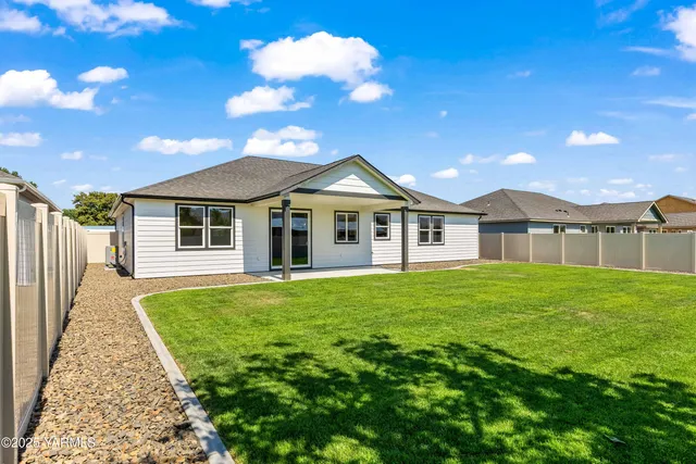 a view of a big house with a big yard and large trees