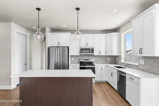 a kitchen with stainless steel appliances a stove sink and refrigerator