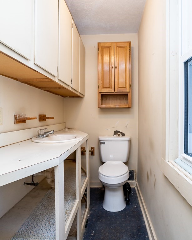 2049 Pleasant Street Three Rivers, MA 01080 - Photo 12 of 19 a bathroom with a sink a toilet and cabinets