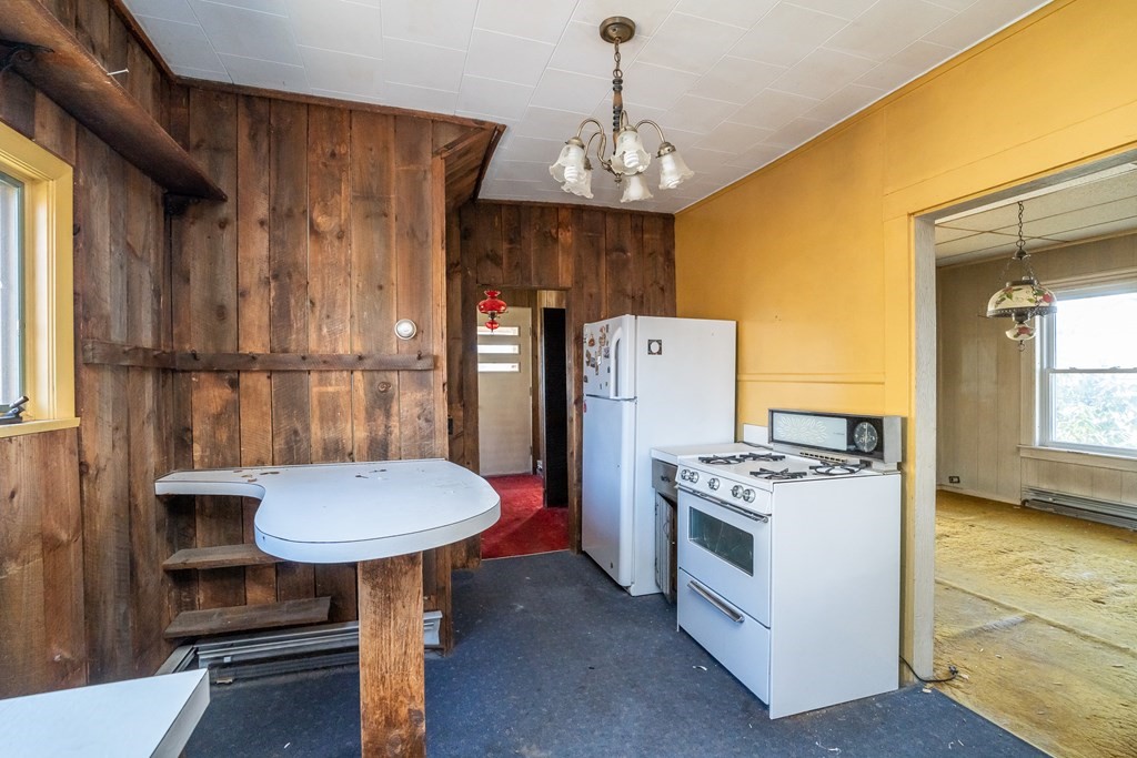 2049 Pleasant Street Three Rivers, MA 01080 - Photo 10 of 19 a kitchen that has a stove a table and chairs in it
