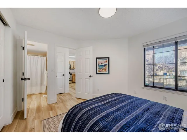 a bedroom with a bed and a large window