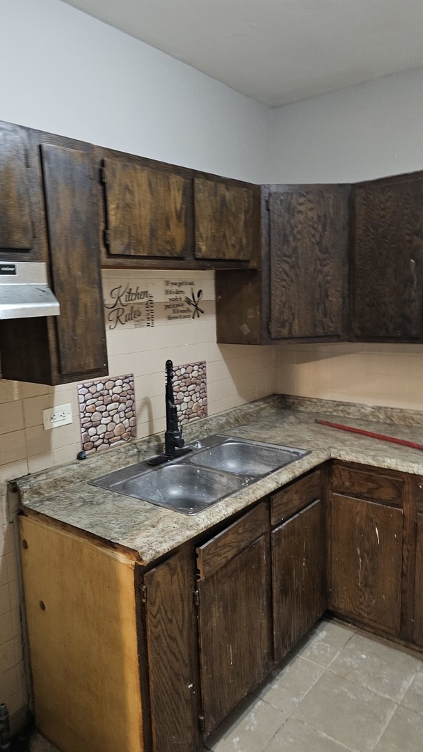 7839 South Loomis Boulevard, Unit 1 Chicago, IL 60620 - Photo 4 of 10 a kitchen with kitchen island granite countertop a sink a stove and cabinets