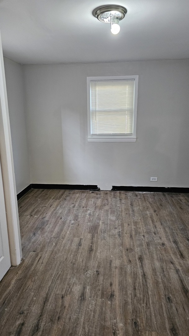 7839 South Loomis Boulevard, Unit 1 Chicago, IL 60620 - Photo 5 of 10 an empty room with wooden floor and windows