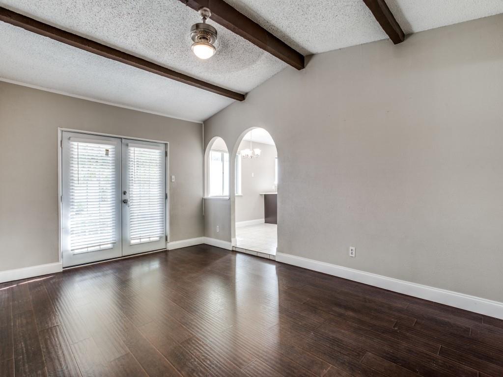 301 Springwillow Road Burleson, TX 76028 - Photo 3 of 12 Empty room featuring a textured ceiling, dark wood finished floors, arched walkways, french doors, and a chandelier
