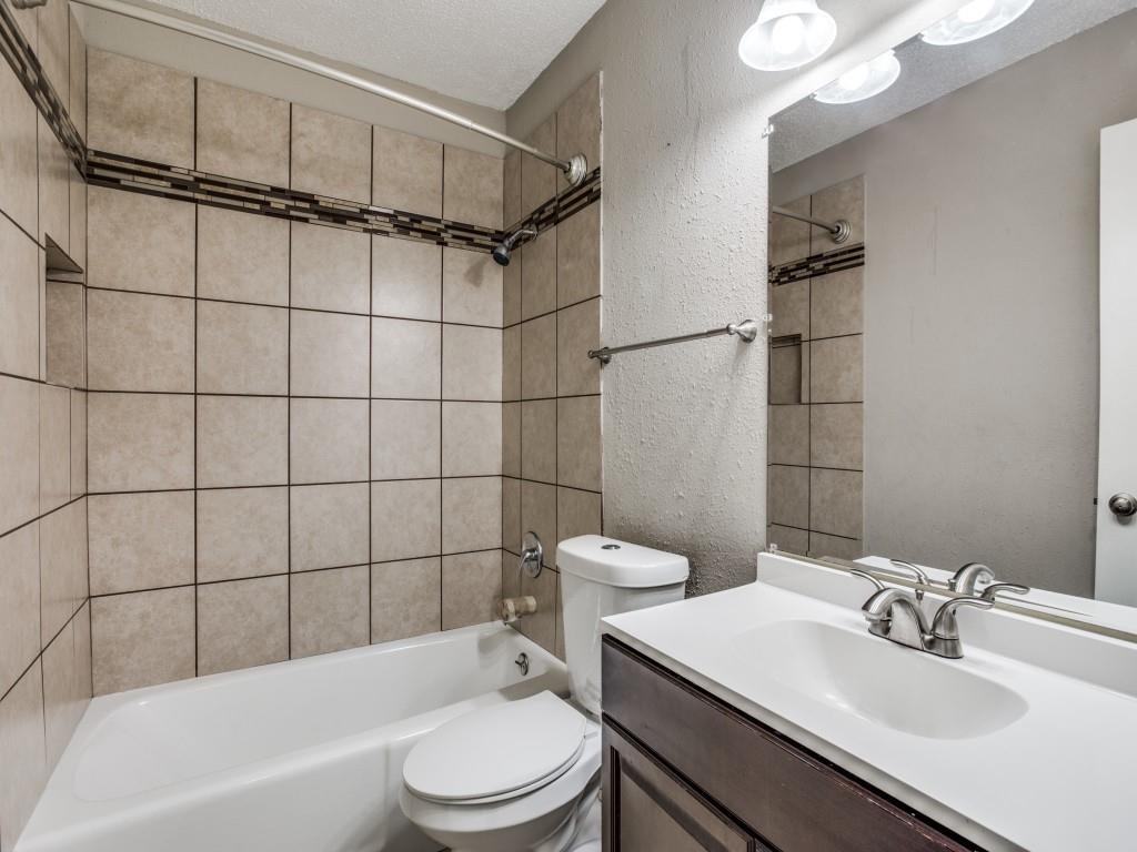 301 Springwillow Road Burleson, TX 76028 - Photo 10 of 12 Full bathroom with a textured wall, vanity, shower / bathtub combination, and a textured ceiling