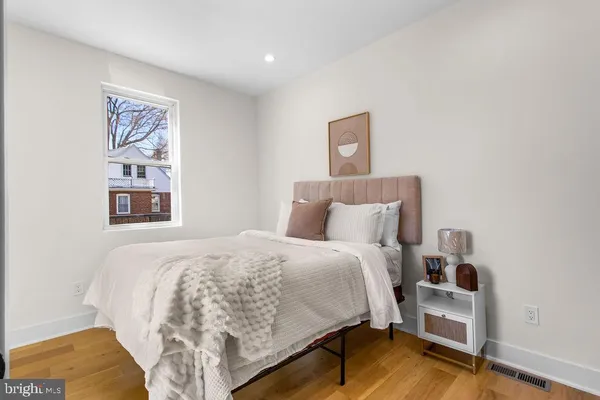 a bedroom with a bed and painting on the wall