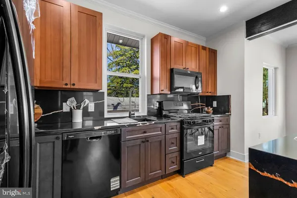 a kitchen with stainless steel appliances a stove a sink dishwasher a microwave oven and a refrigerator