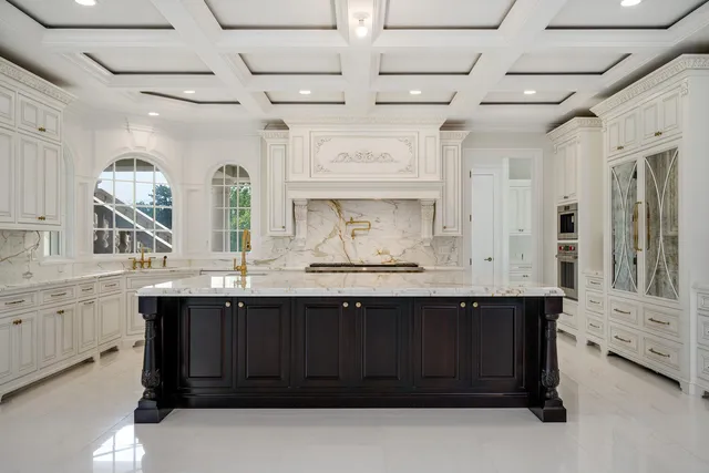 a kitchen with white cabinets and window