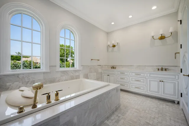 a bathroom with a sink a vanity a window and a mirror