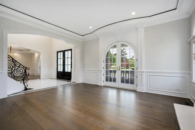 a view of an empty room with wooden floor fireplace and a window