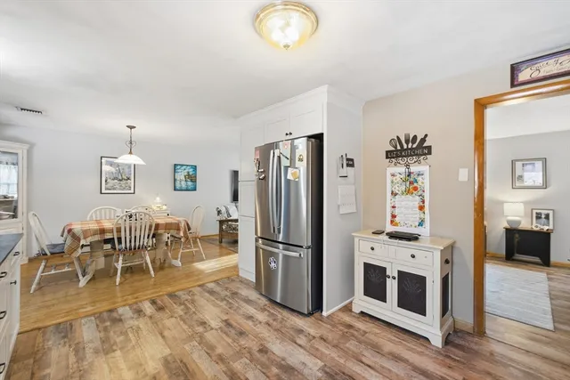 a view of a dining room with furniture a chandelier and wooden floor