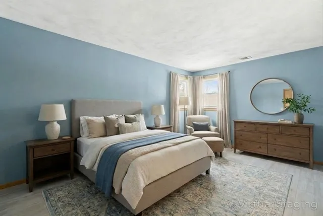 a bedroom with a bed mirror on dresser and a window