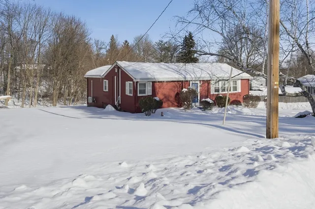 a front view of a house with a yard and trees