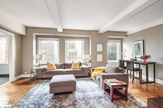 a living room with furniture wooden floor and a large window