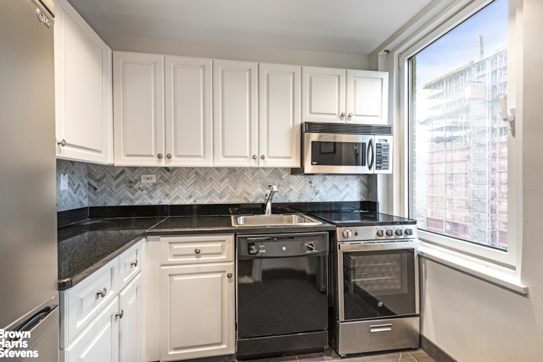160 Central Park South, Unit 3011 Manhattan, NY 10019 - Photo 5 of 7 a kitchen with appliances a sink and a microwave