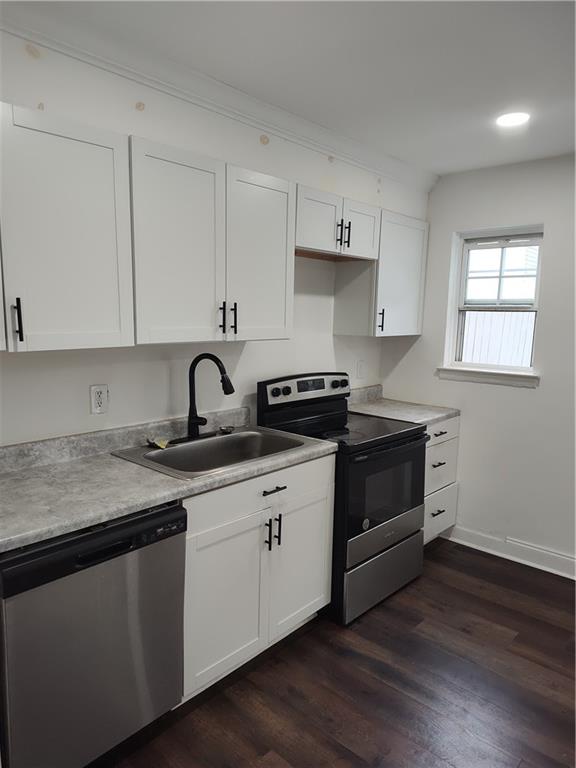 a kitchen with white cabinets stainless steel appliances and sink