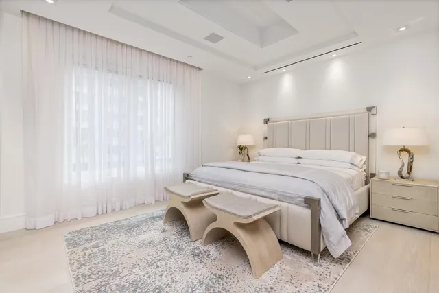 a large bed sitting in a bedroom next to a window