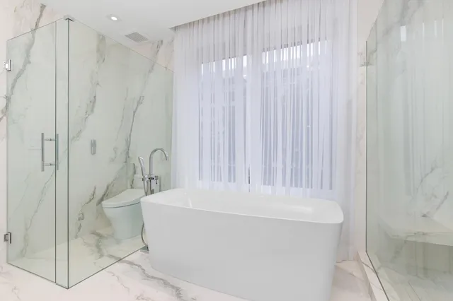 a bathroom with a granite countertop sink a toilet and a shower