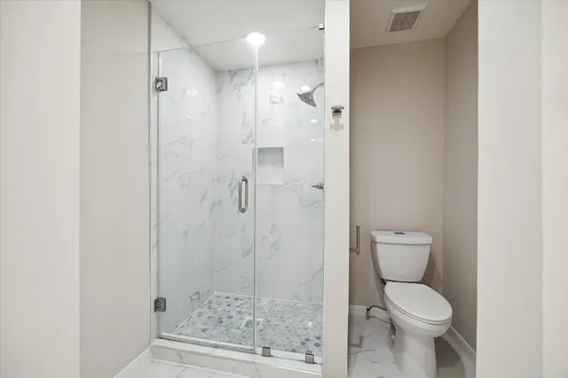 a bathroom with a toilet and a shower