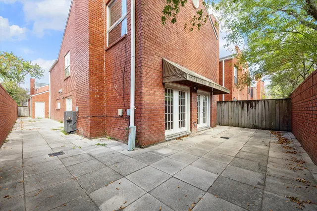 a view of backyard with large trees and wooden fence