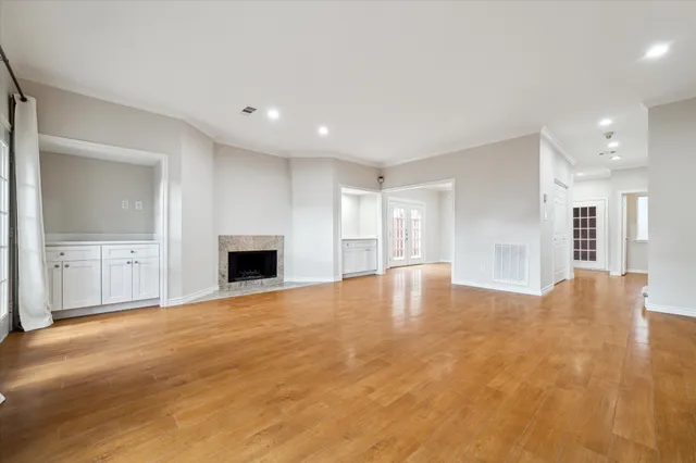 a view of empty room with wooden floor and windows