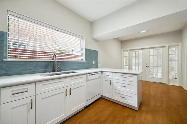 a kitchen with granite countertop white cabinets and white appliances