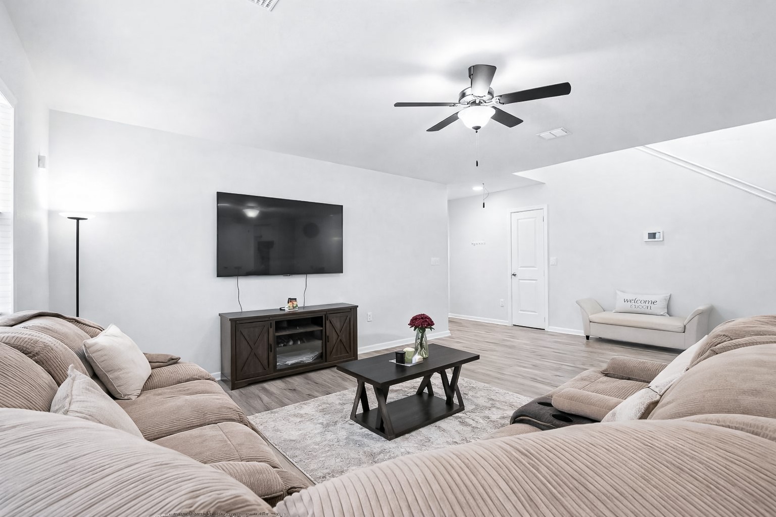 940 Paddock Lane Georgetown, TX 78626 - Photo 9 of 32 Bright living area featuring wood-finish flooring, a contemporary ceiling fan, white interior walls, and a built-in wall thermostat