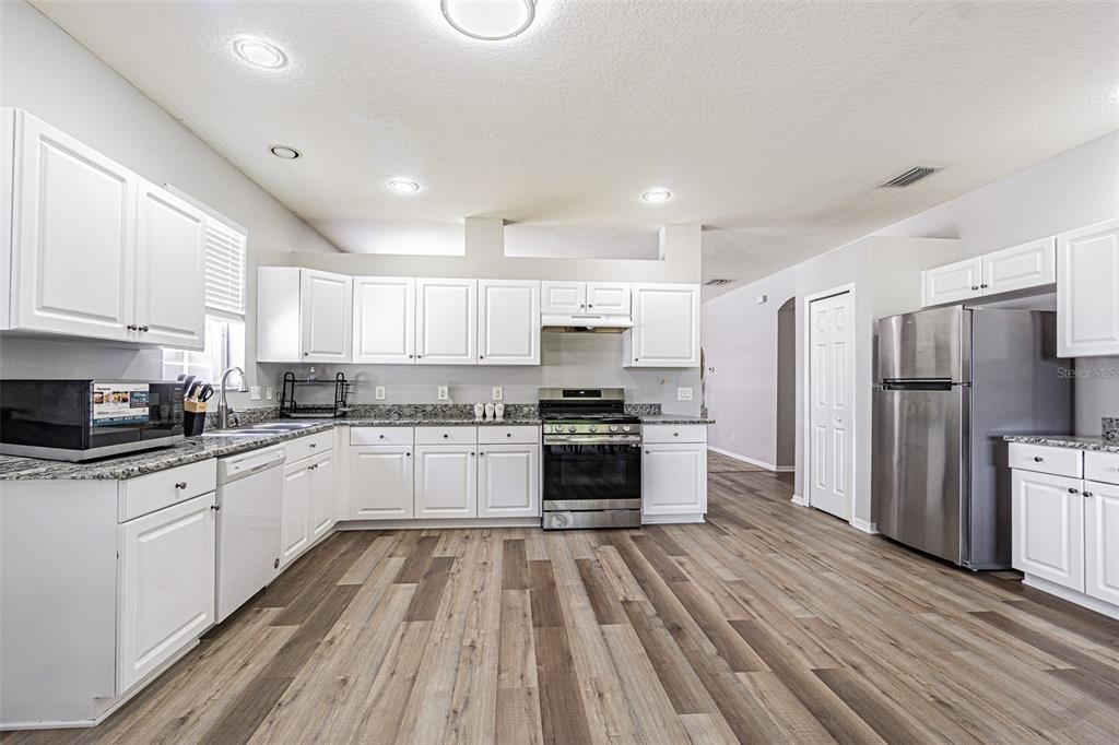 13016 Terrace Brook Place Temple Terrace, FL 33637 - Photo 4 of 27 a large kitchen with a white stove top oven and refrigerator
