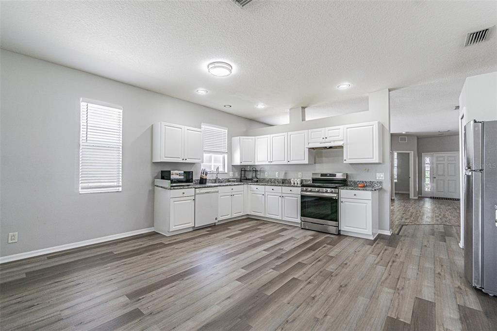 13016 Terrace Brook Place Temple Terrace, FL 33637 - Photo 5 of 27 a kitchen with a refrigerator and white cabinets