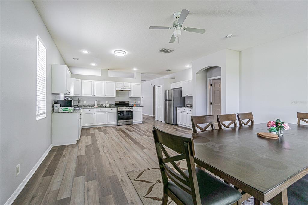 13016 Terrace Brook Place Temple Terrace, FL 33637 - Photo 6 of 27 a kitchen with stainless steel appliances granite countertop a refrigerator a sink dishwasher a stove and white countertops with wooden floor