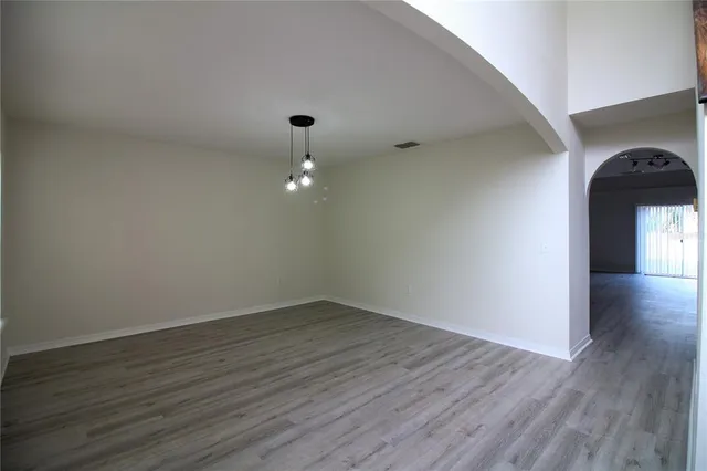 a view of empty room with wooden floor and window