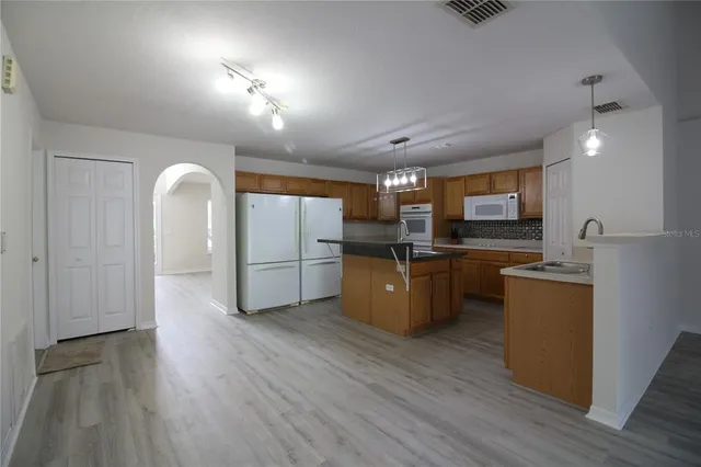 a kitchen with refrigerator cabinets and wooden floor
