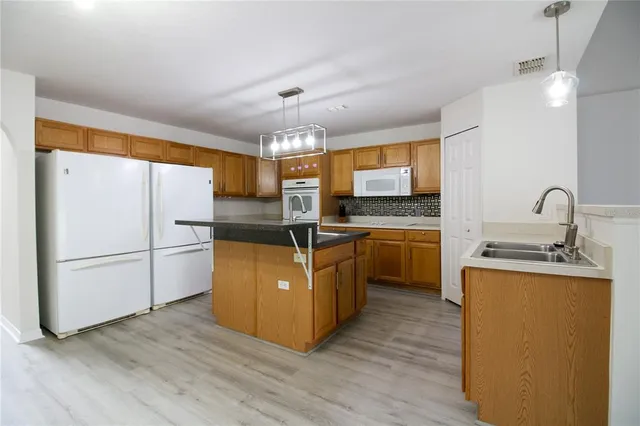 a kitchen with sink a microwave and refrigerator