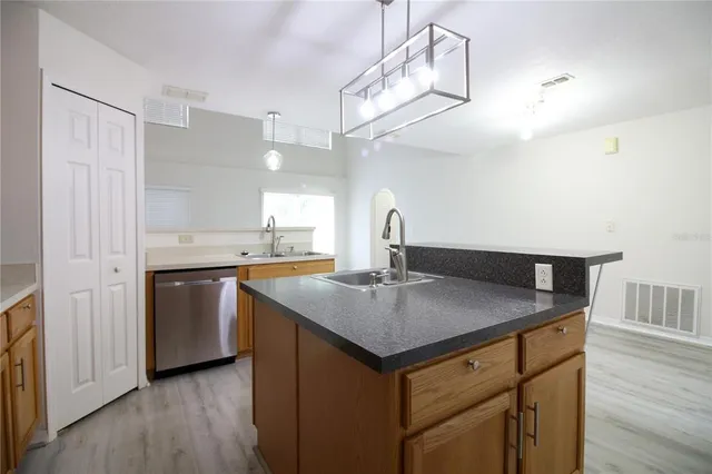 a kitchen with a sink a counter space and wooden floor