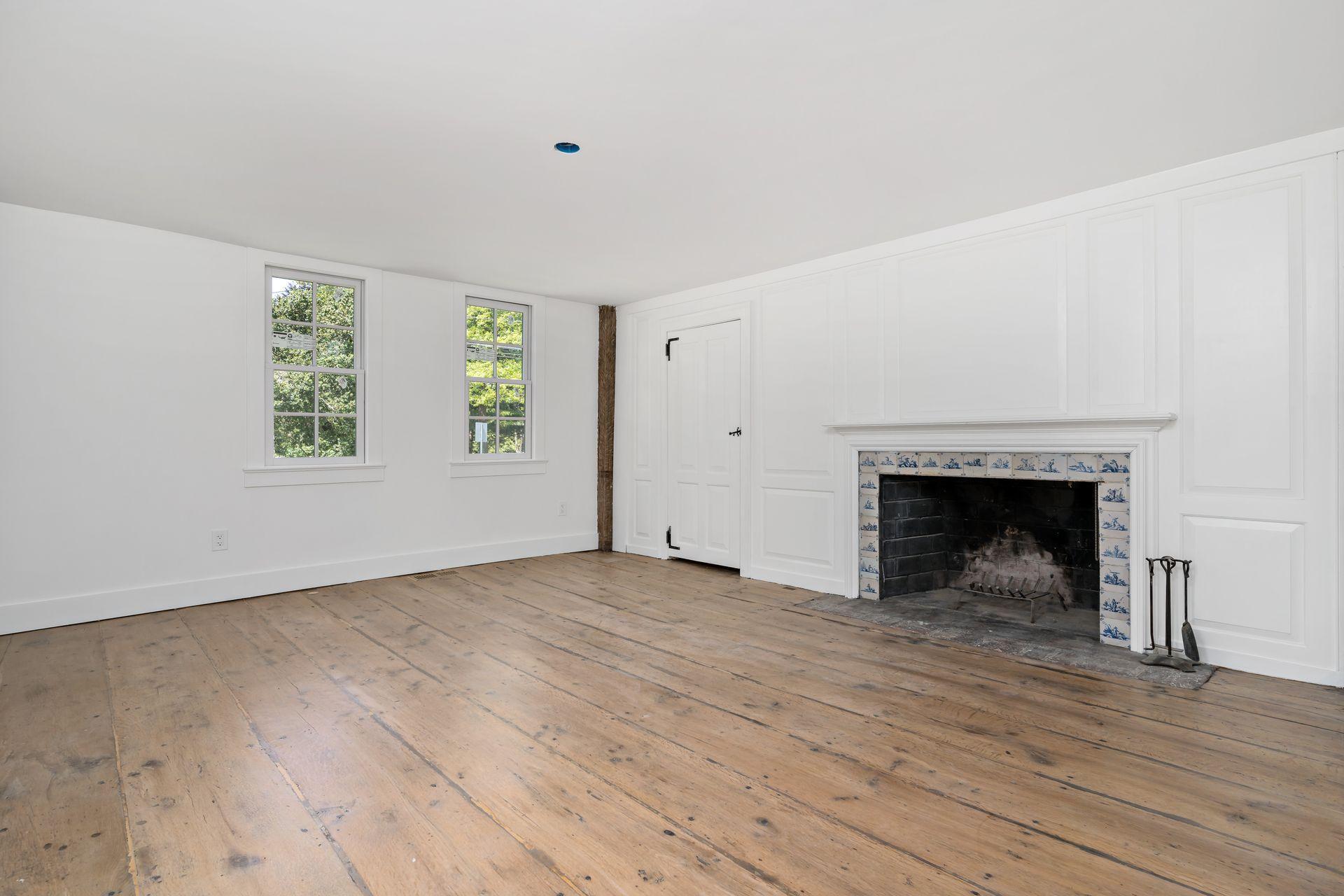 129 Davenport Ridge Road Stamford, CT 06903 - Photo 23 of 43 a view of an empty room with wooden floor fireplace and a window