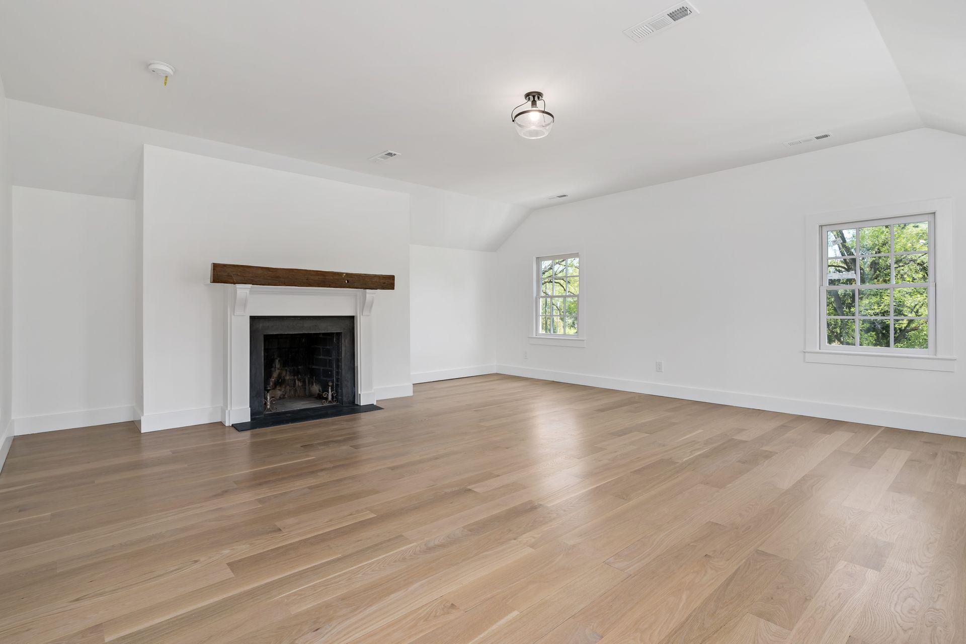 129 Davenport Ridge Road Stamford, CT 06903 - Photo 27 of 43 an empty room with wooden floor a fireplace and windows