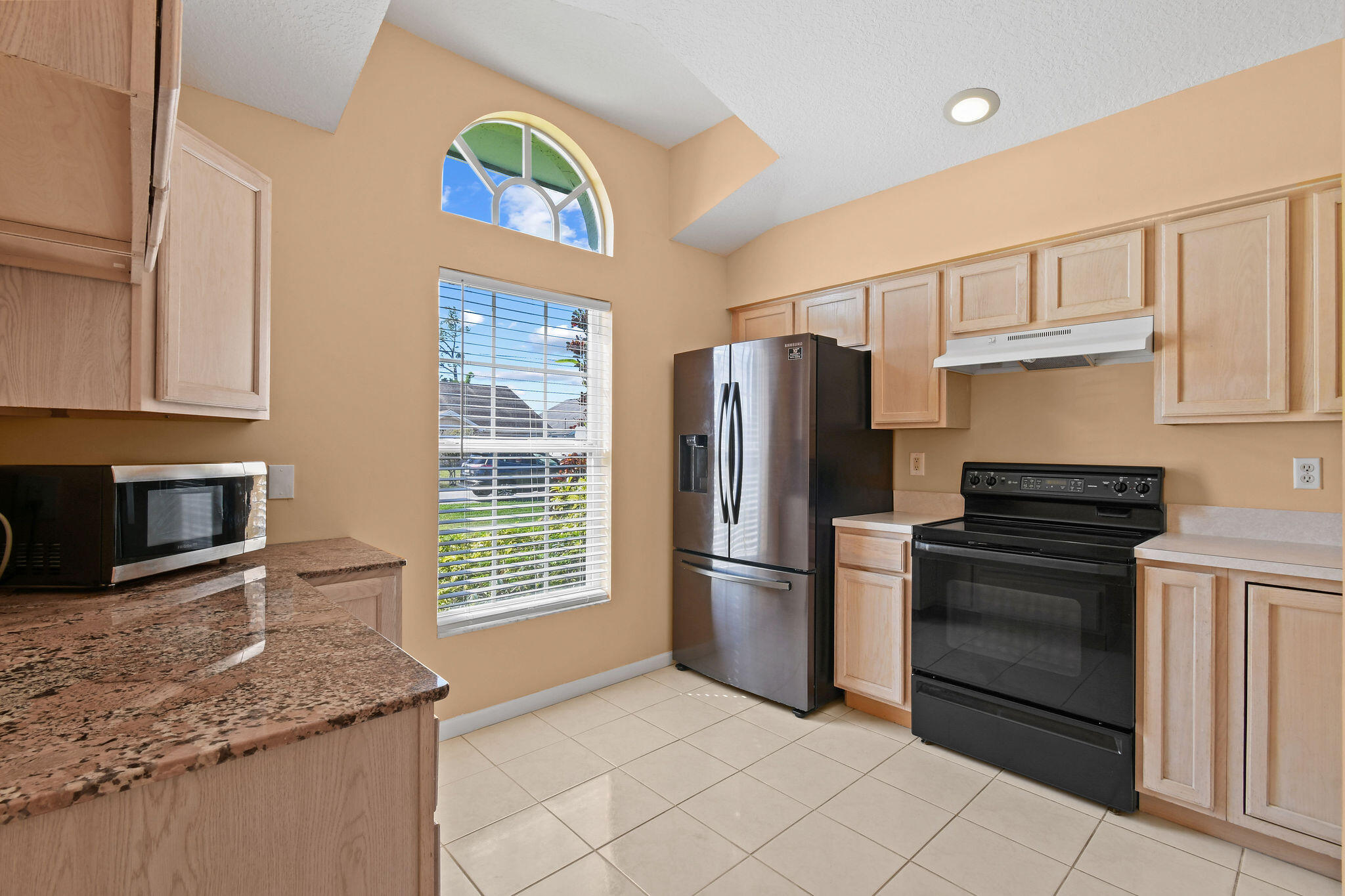 6293 Michael Street Jupiter, FL 33458 - Photo 12 of 64 a kitchen with stainless steel appliances granite countertop a refrigerator stove and microwave